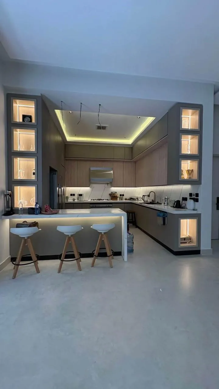 Cuisine Bois et Confort installée chez un client, vitrines éclairées et bar